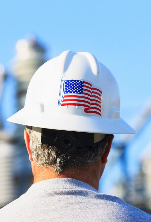 A person wearing a white hardhat with a usa flag on the back.
